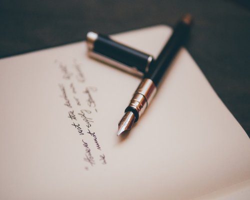 A clean desk with a letter and a pen