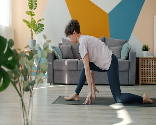 A woman doing gentle stretching in a cozy living room